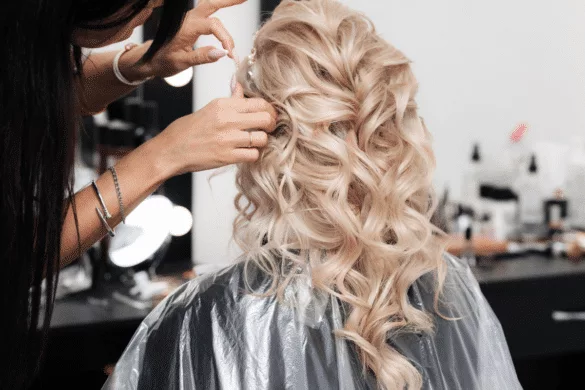 Blond girl having her hair styled for Prom by a hair stylist.